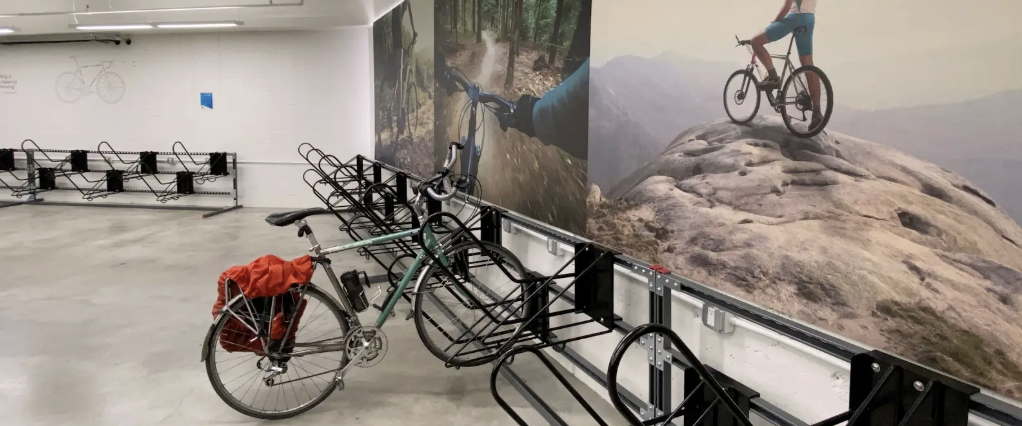 A bike pack is parked in a rack in an indoor bike room.