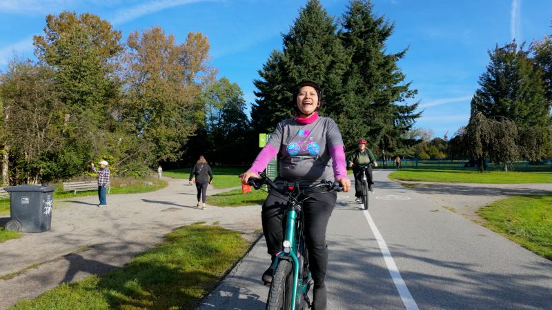 A woman rides her bike on a separated cycling path. The photo credit is Tim Chung.