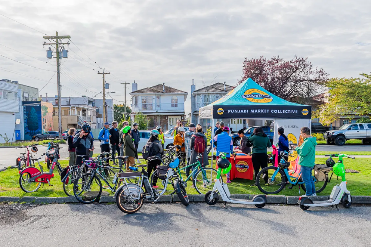group of people on bikes facing a community tent