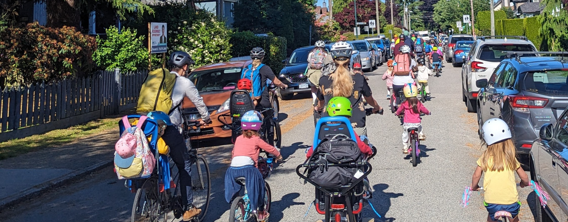 A group of people ride in a bike bus away from the camera.