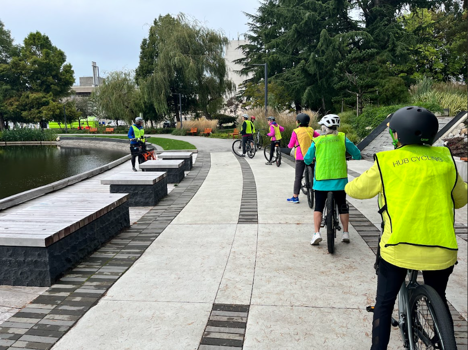 Group of cyclist ride past an instructor