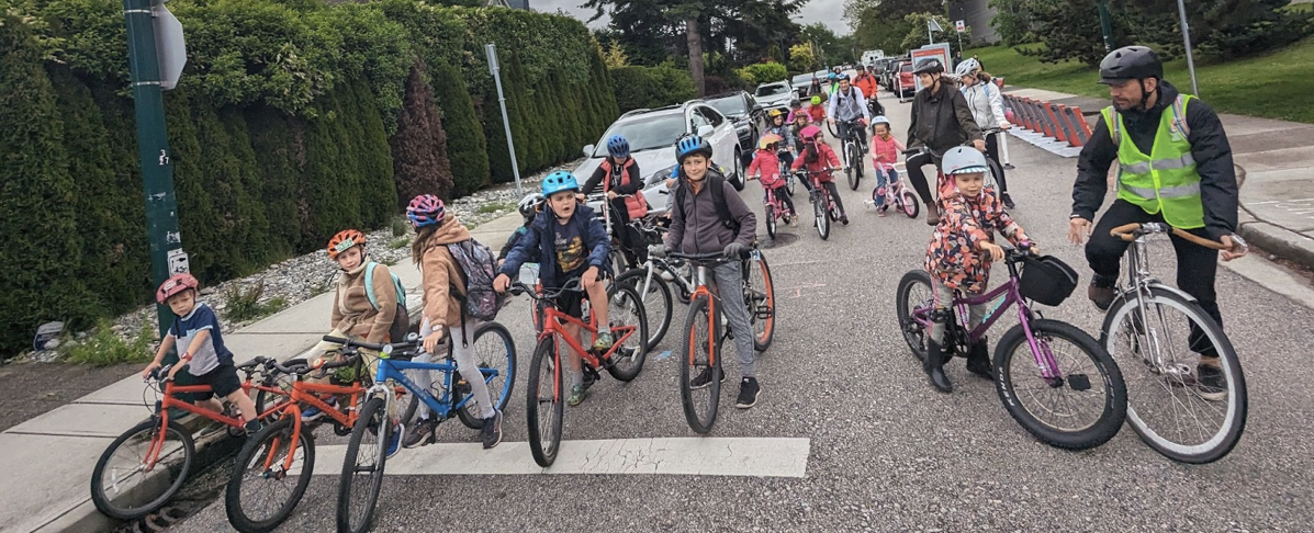 A group of students ride their bikes to school in a bike bus. 