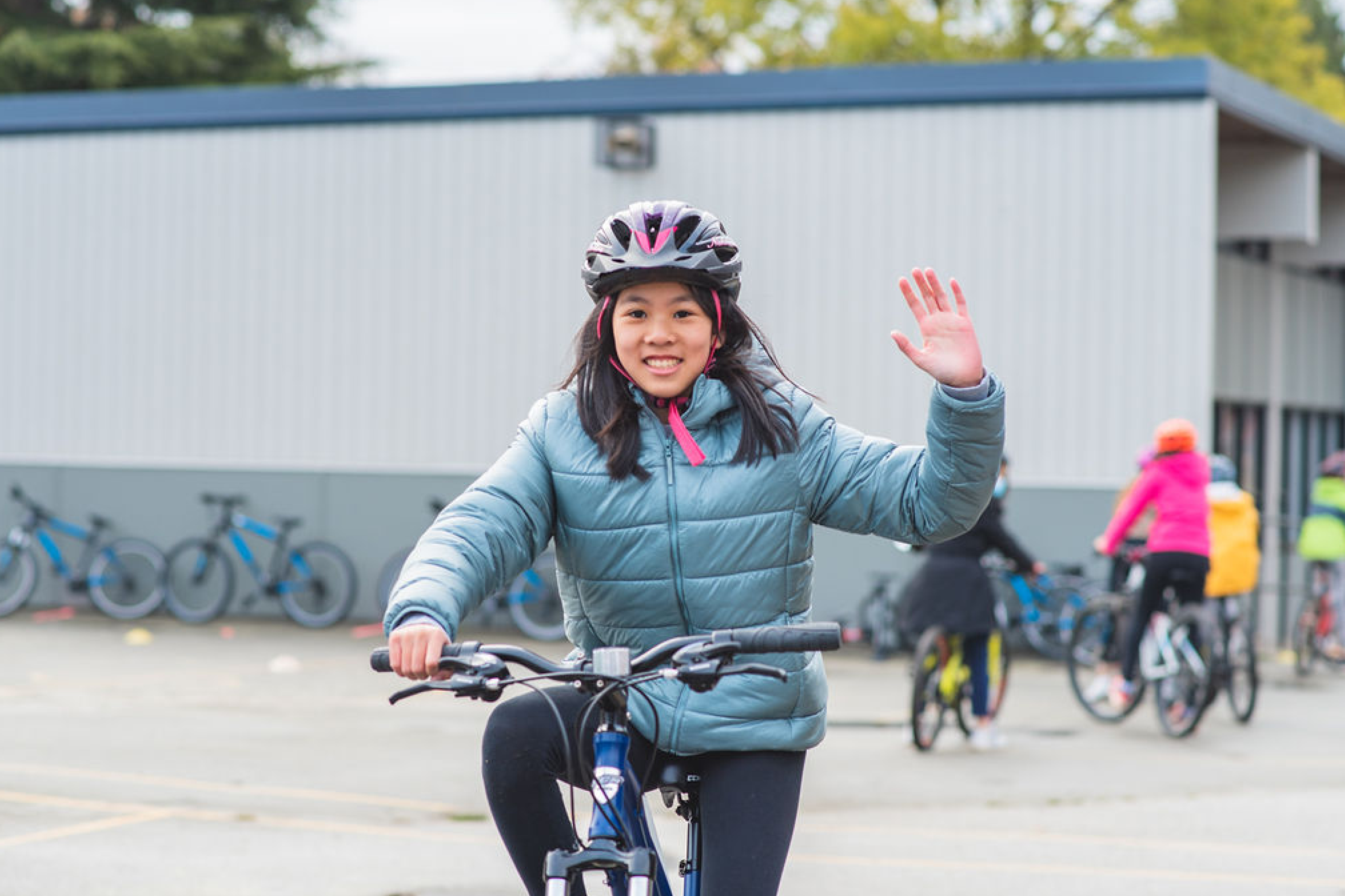 A young girl rides her bike on school grounds.