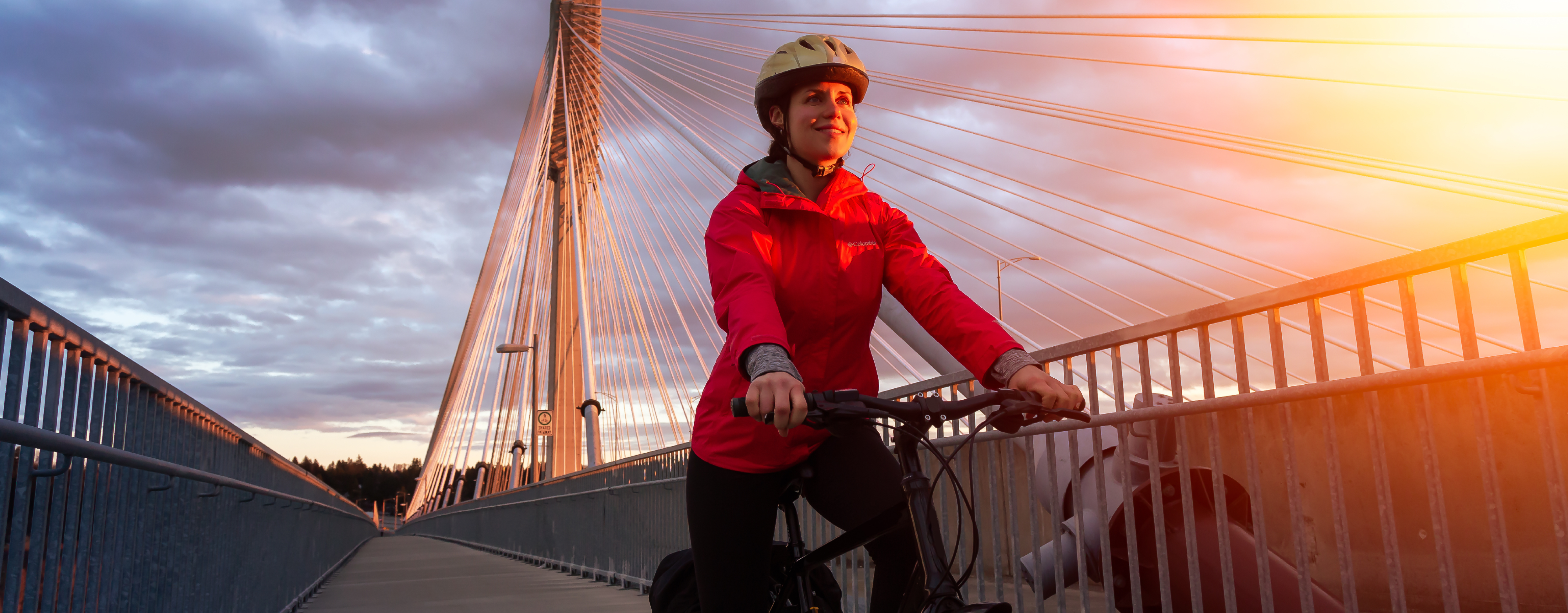 A woman in her 30s rides her bike over the Port Mann Bridge in Surrey.