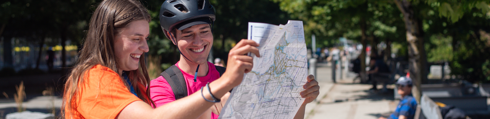 A young man and woman look at a bike map together.