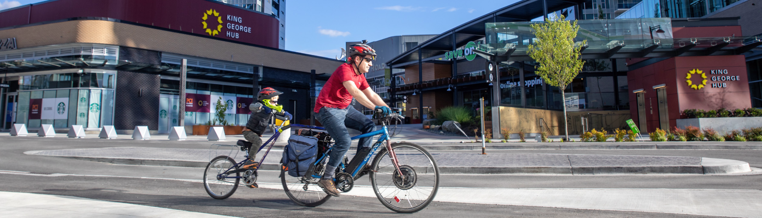 A father and his son cycle in downtown Surrey on separated cycling infrastructure.