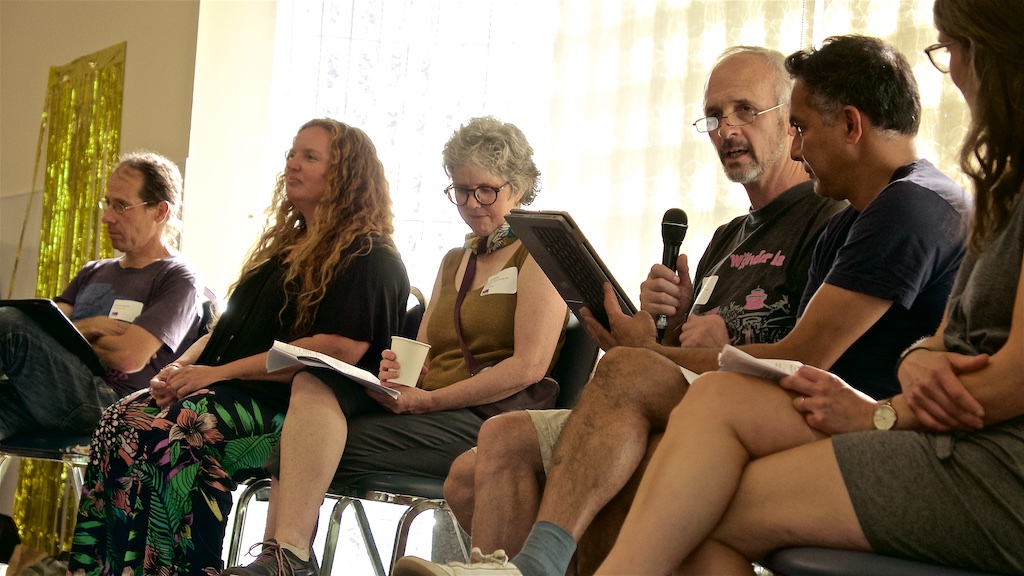 Six people engage in a panel discussion.