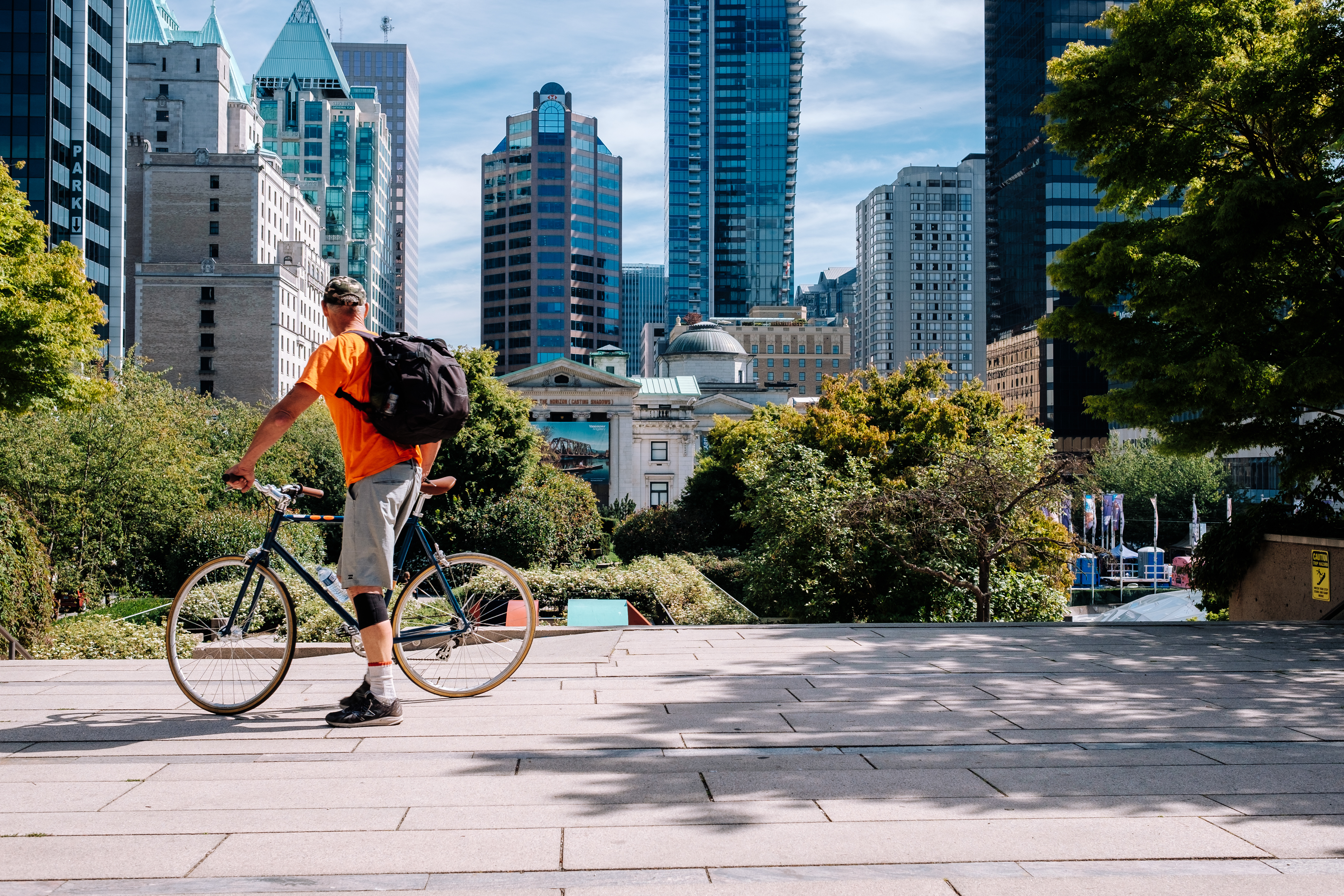 A person cycling stops to look at Vancouver's building landscape.