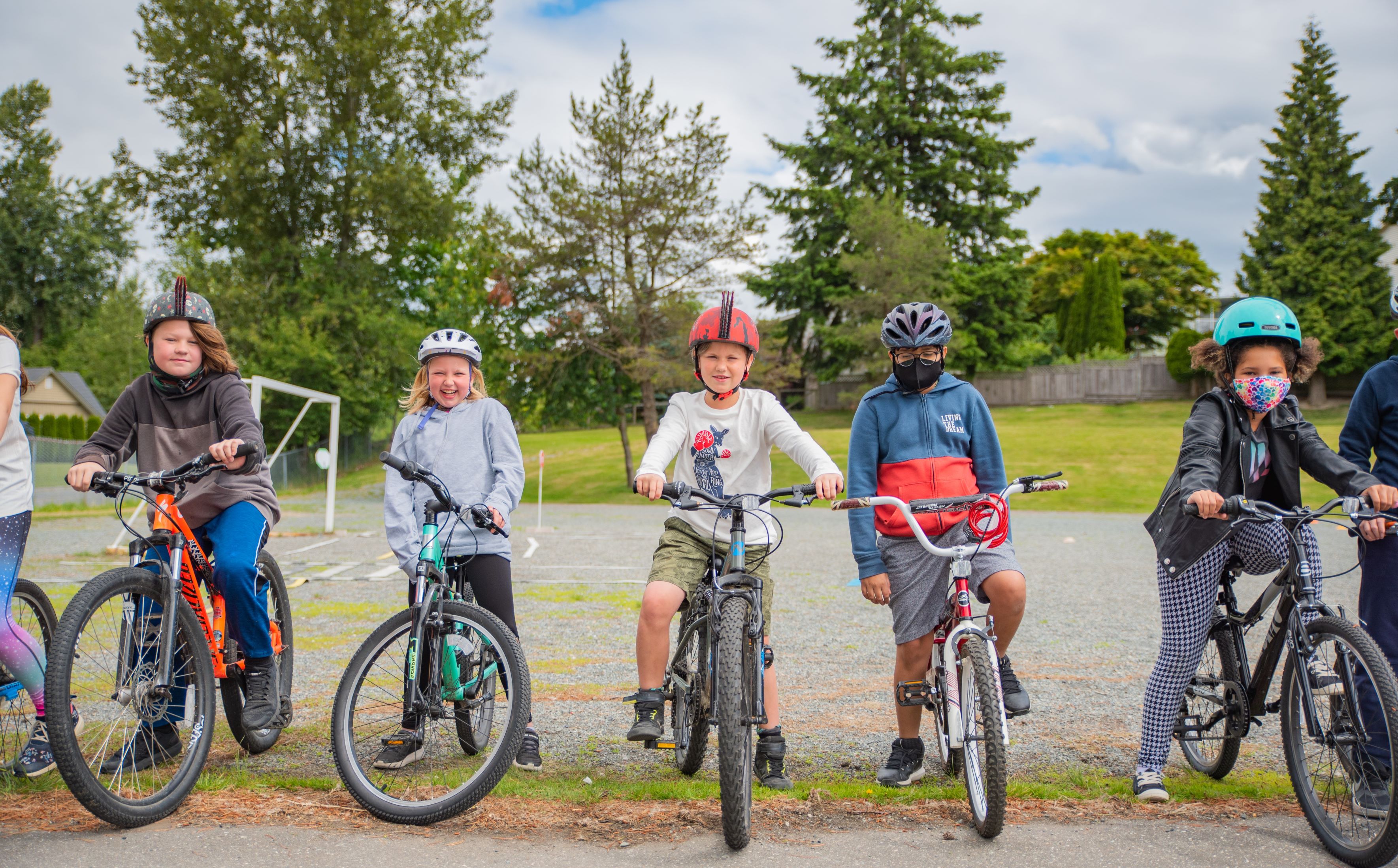 A group of elementary aged students stand with their bikes.