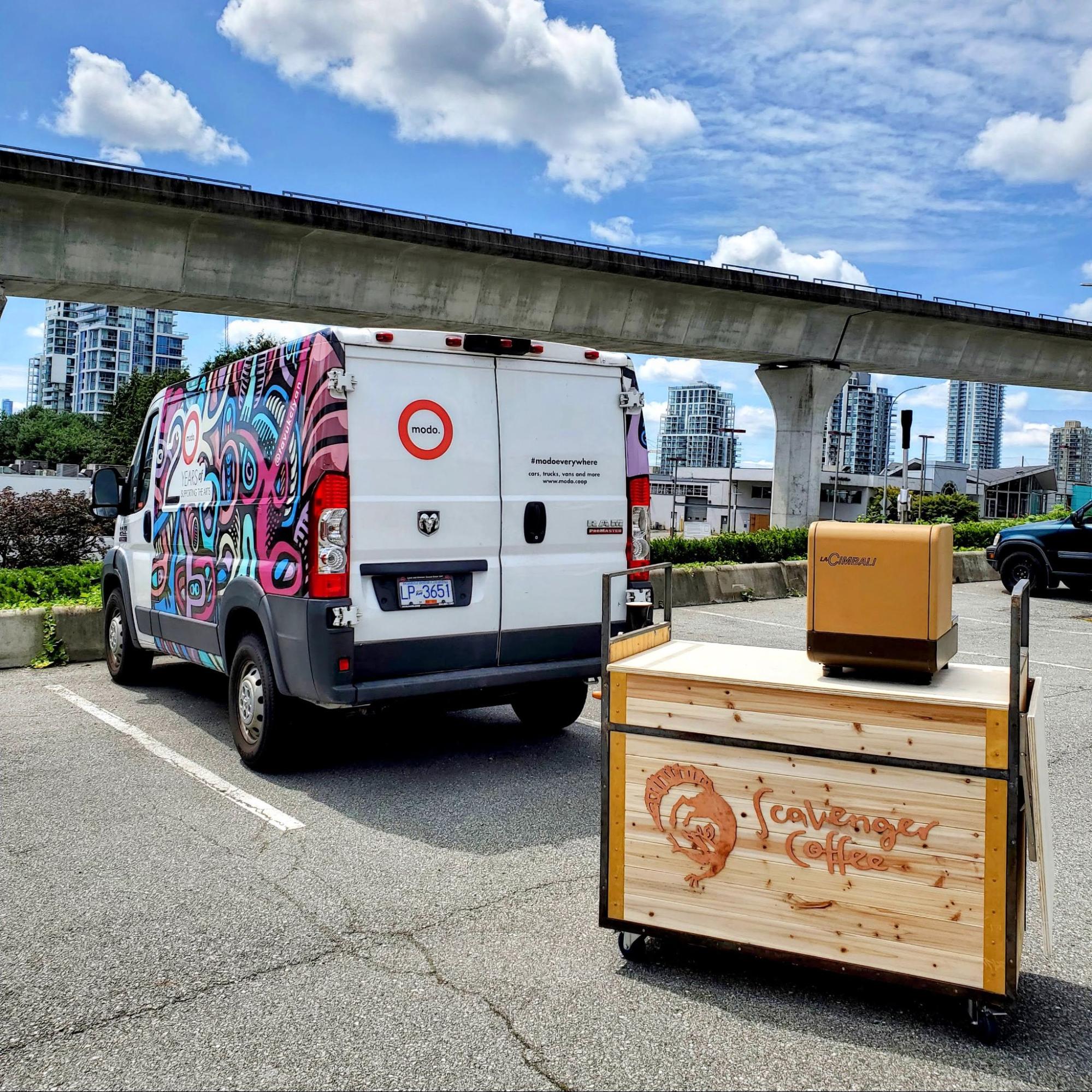 Modo's Ram Promaster cargo van parked beside Scavenger Coffee's mobile coffee cart.
