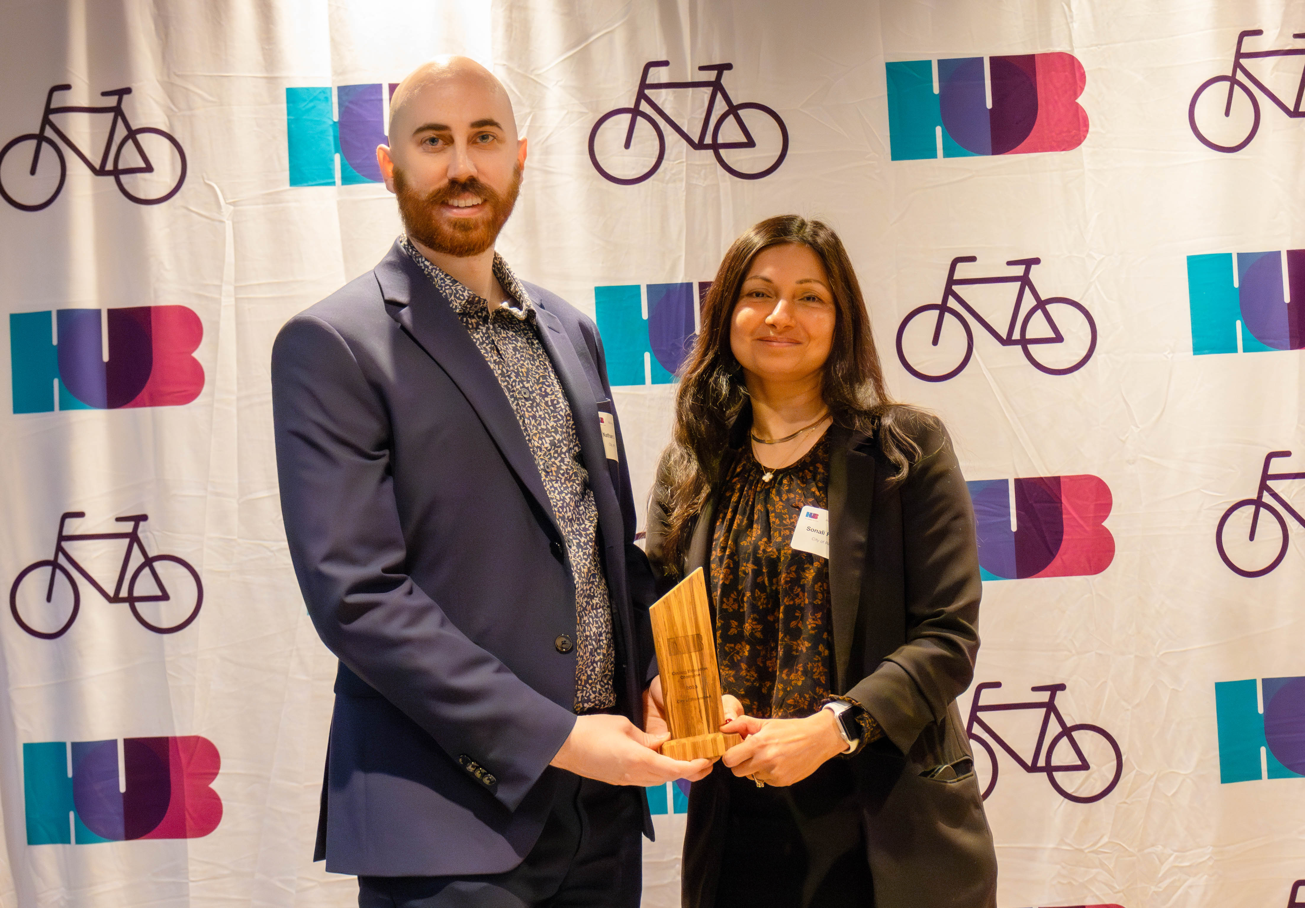 Two winners from the City of Richmond hold the HUB Cycling Cycling Education Champion of the Year Award.