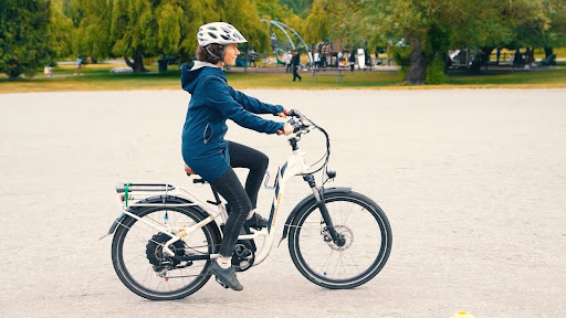 A woman rides an e-bike in a park.