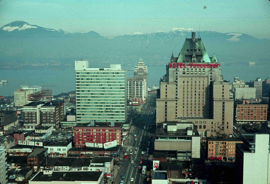 An aerial view of Vancouver's downtown buildings in 1966. There are several buildings of varying sizes including towers and small apartment buildings.