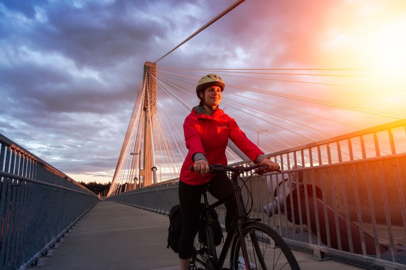 A woman in her 30s rides her bike over the Port Mann Bridge.