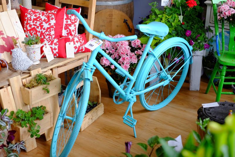 A painted blue bike surrounded by flowers 