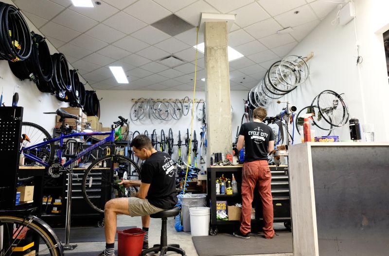 Two Cycle City mechanics work on bikes in the shop.